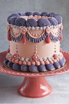 a pink and purple cake sitting on top of a red plate