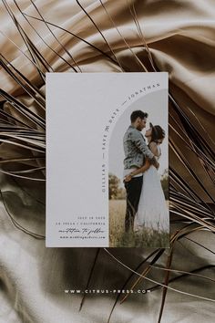 an image of a couple on their wedding day with the save the date card in front