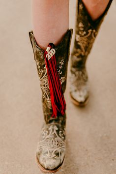 a person wearing cowboy boots with a tassel