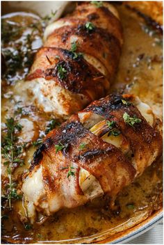 two pieces of chicken in a pan with herbs on top