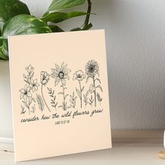 a card with some flowers on it next to a potted plant and a vase