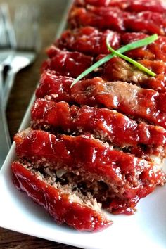 sliced meatloaf on a white plate with fork and knife