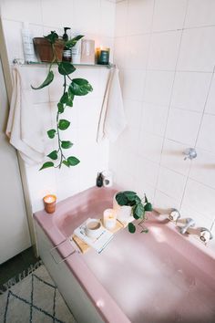 a bathroom sink with a towel hanging over it's edge next to a plant