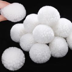 white pom - poms are being held by someone's hand