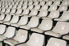 rows of empty seats in a stadium or baseball field with numbers on the seat back