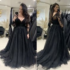 a woman in a black dress taking a selfie