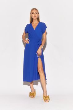 Make a striking entrance in this royal blue midi dress from Meghan LA. Featuring a flattering surplice V-neckline and elegant cuffed bell sleeves, it adds a touch of sophistication to any occasion. The elastic waist with a self-tie belt ensures a comfortable fit, while the flowing mid-length skirt creates graceful movement. Crafted from butter-soft fabric in a bold royal blue, this dress is perfect for fall events. Available in plus sizes. Summer Midi V-neck Dress With Tie Waist, Solid Color Belted V-neck Midi Dress, Belted Midi Dress With V-neck, Chic Midi Dress With Surplice Neckline For Brunch, Blue Wrap Dress With Tie Waist And Surplice Neckline, Solid Color Maxi Dress With Surplice Neckline For Spring, Spring Solid Color Maxi Dress With Surplice Neckline, Short Sleeve Tie Waist Wrap Dress For Party, Blue Wrap Dress With Tie Waist