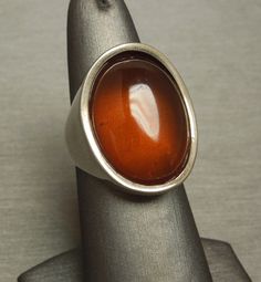 "Vintage Circa 1970 in a Euro Art Deco Style Constructed of Sterling Silver with 1 Oval shaped piece of Natural Amber Top section of ring measuring approximately 1\" in length & about 9.9mm high when on the finger Stamped: 925 Additional photos/details upon request. Finger Size 7.5 *Sizing upon request (Sizing down runs about $25.. Sizing up starts at $45) Weighing 11.4 grams *Sale of ring includes an appraisal certificate for your insurance purposes. All pieces shipped insured via USPS Prio Retro Polished Rings For Formal Events, Retro Formal Rings With Polished Finish, Retro Rings With Polished Finish For Formal Occasions, Vintage Brown Ring With Polished Finish, Mid-century Polished Formal Jewelry, Modernist Oval Rings For Formal Events, Modernist Oval Rings For Formal Occasions, Modernist Formal Cabochon Rings, Brown Hallmarked Vintage Ring