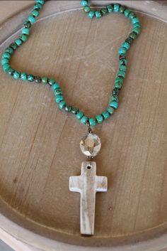 Enhance your style with this unique Turquoise Necklace. The carved Antler Cross Pendant adds a touch of vintage charm, while the quality materials and craftsmanship ensure long-lasting beauty. Perfect for any occasion, this necklace is sure to become a timeless addition to your jewelry collection. 35" turquoise dyed howlite beads with hand carved antler cross Cross is approx 3' long Bohemian Turquoise Cross Jewelry, Bohemian Turquoise Cross Necklace, Rustic Turquoise Necklace With Natural Stones For Gift, Rustic Turquoise Necklaces With Natural Stones, Rustic Turquoise Necklace For Gift, Rustic Turquoise Beaded Necklace For Gift, Rustic Turquoise Beaded Necklace Gift, Long Turquoise Necklace, Carved Antler