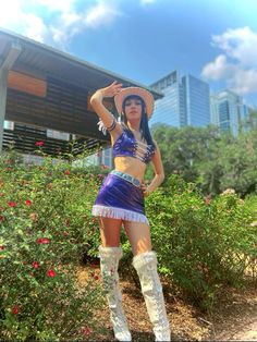 a woman in a purple outfit and cowboy hat