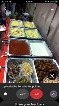 several trays of food are lined up on a table