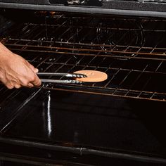 a person is pulling something out of an oven with two tongs on the rack