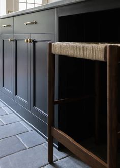 an empty kitchen with black cabinets and wood handles on the countertop, along with a roped area for storage