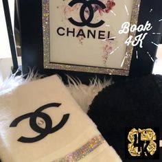 the chanel towel is next to a black and white teddy bear with glitter on it