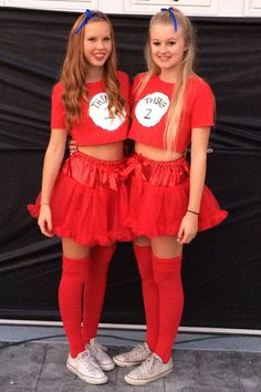 two girls in red outfits standing next to each other with their hands on their hips