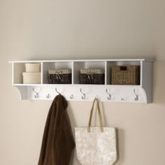 a white coat rack with three hooks and two baskets hanging on it's sides