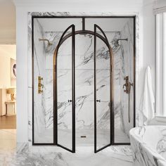 a marble bathroom with an arched shower door