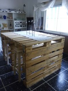 a kitchen island made out of pallets and wooden planks in front of a window