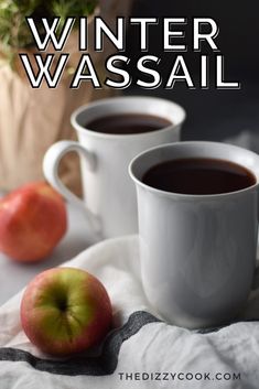 two mugs of coffee and an apple on a cloth next to a potted plant