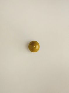 a yellow object is on the wall in front of a white background with no one around it