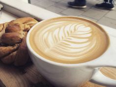 a cup of coffee and some bread on a table