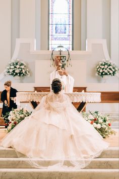 a woman in a wedding dress kneeling down at the alter with her hands on her hips