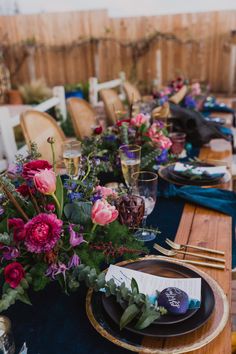 the table is set with flowers and place settings for dinner guests to sit down at