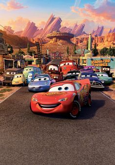 cars are lined up in the parking lot at disney's cars movie resort, with mountains in the background