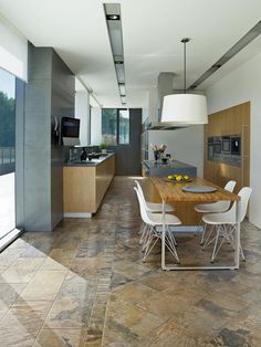 a kitchen with a table and chairs next to an oven in the middle of it