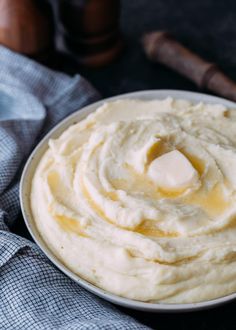 a white plate topped with mashed potatoes on top of a blue and white towel