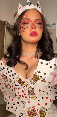 a woman with makeup on her face and some playing cards around her neck is posing for the camera