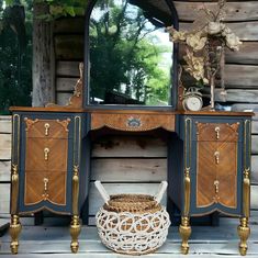 an antique dresser with a mirror and wicker basket on it's sideboard