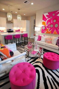 a living room filled with lots of furniture and pink accents on top of zebra print rug