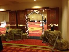 hay bales are stacked on top of each other in front of an archway decorated with fairy lights