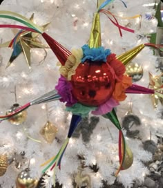 an ornament is hanging on the tree in front of a white christmas tree