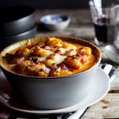 a white bowl filled with food on top of a wooden table