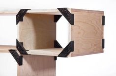 a wooden shelf with two black brackets on the front and one is open to show its contents