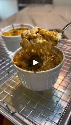 two white bowls filled with food on top of a metal rack