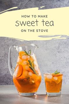 a pitcher filled with orange juice and garnished with rosemary, sitting next to a glass full of iced tea