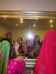 a group of women standing in front of a mirror