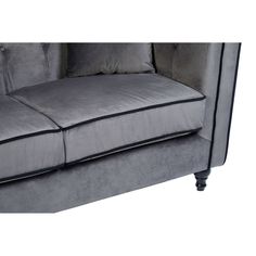 a gray couch with two pillows on the back and one arm folded up to it's side