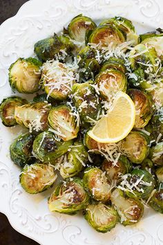 brussel sprouts with lemon and parmesan cheese on a white plate