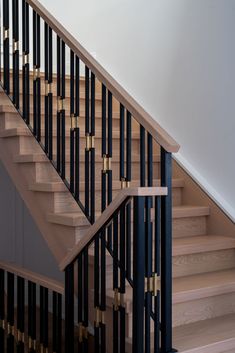 a wooden stair case with metal railing and handrail