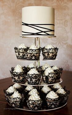 cupcakes are arranged on a three tiered cake stand with white frosting