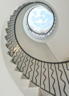 a spiral staircase with a skylight above it