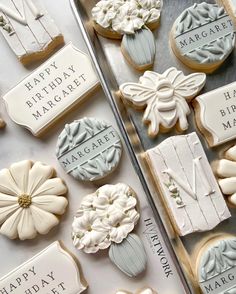 decorated cookies are sitting on a table with happy birthday magnets and name tags attached to them