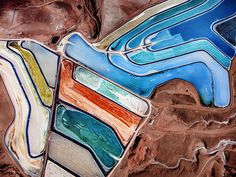 an aerial view of mountains and valleys with colorful lines in the center, including blue, green, yellow, orange, and red