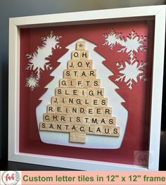 a wooden scrabble christmas tree with white snowflakes on red background and custom letter tiles