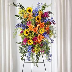 an arrangement of colorful flowers on a stand