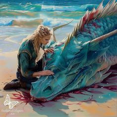 a woman is painting a dragon on the beach